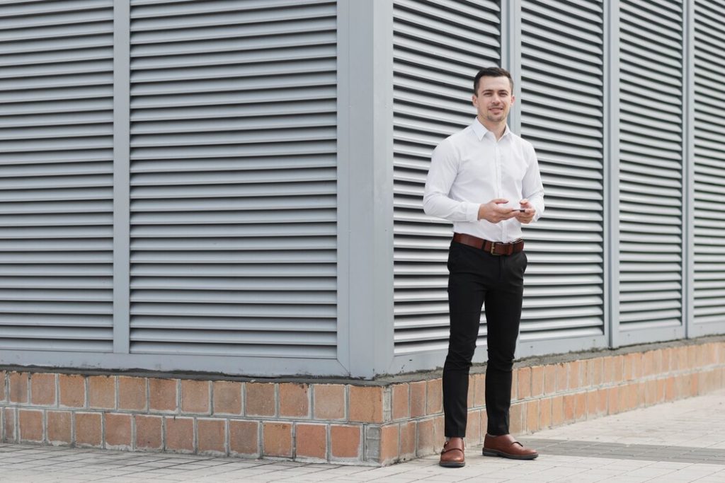 man standing on street in white shirt and black pant